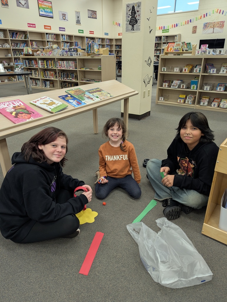 three students making a paper chain