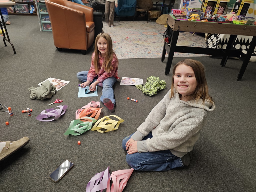 two students doing snowflake craft