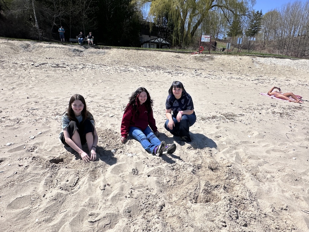 three students in the sand
