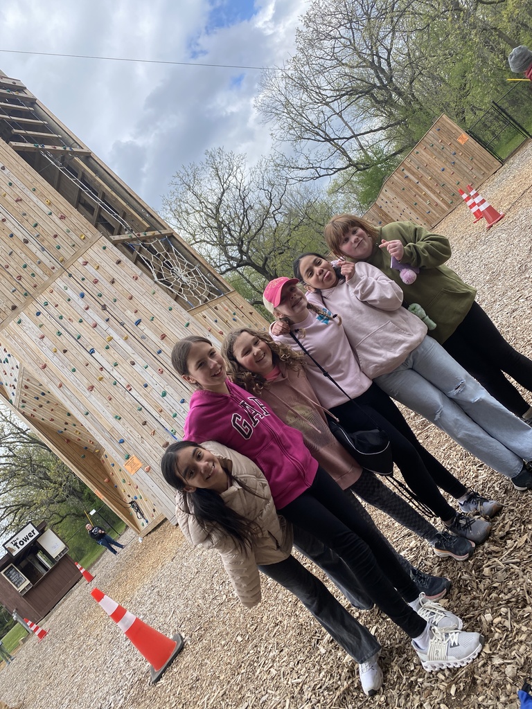 Students in front of rock climbing wall. 