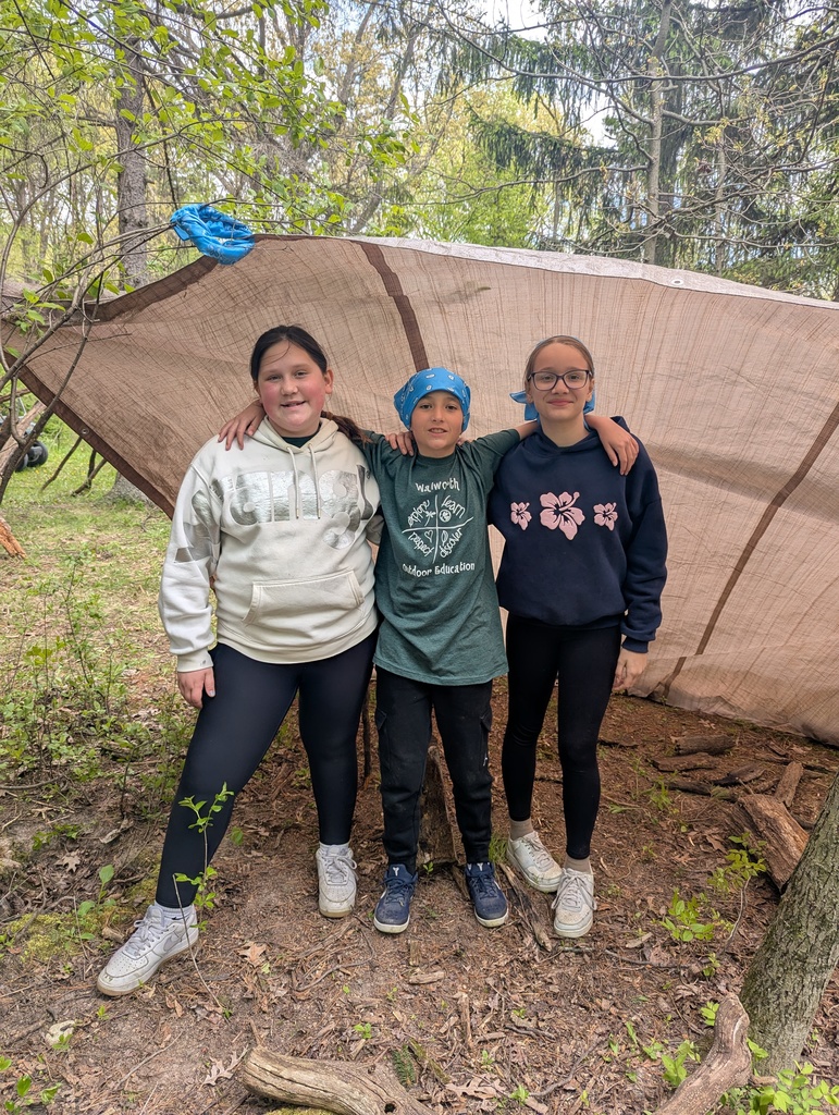 three students in front of a fort at camp