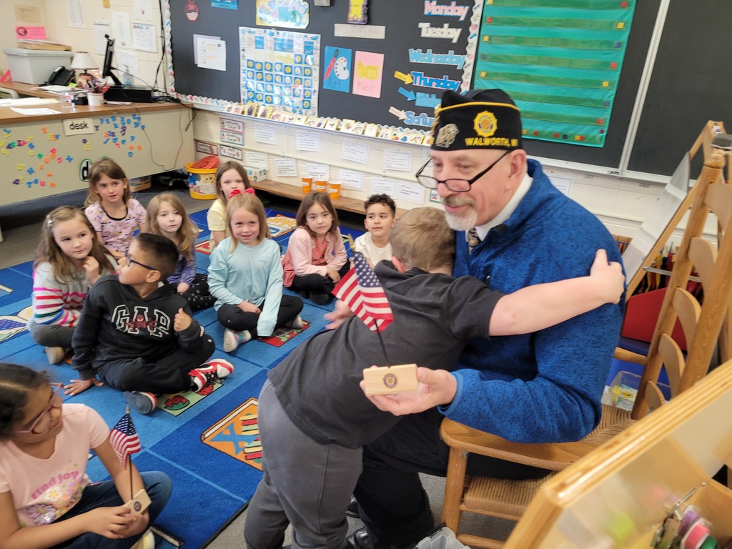 Mr. Kahl presenting flag to kindergarten student