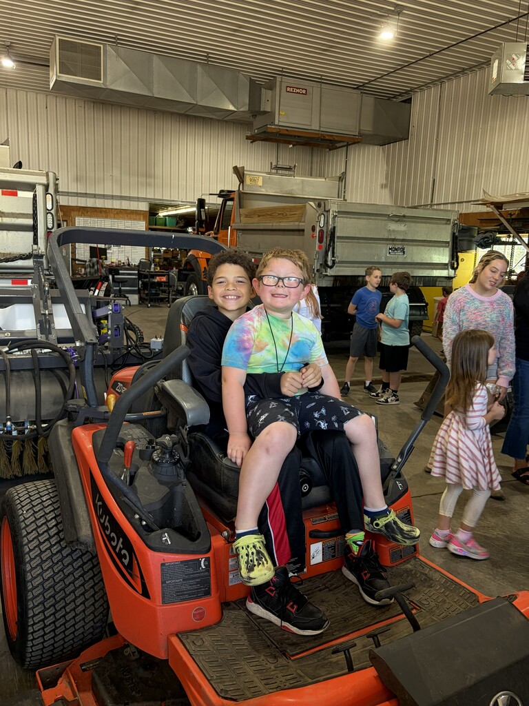 2 students on a lawn mower
