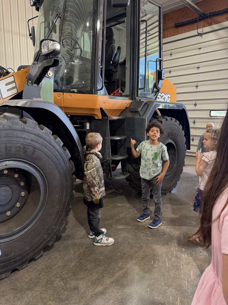2 students next to a bulldozer