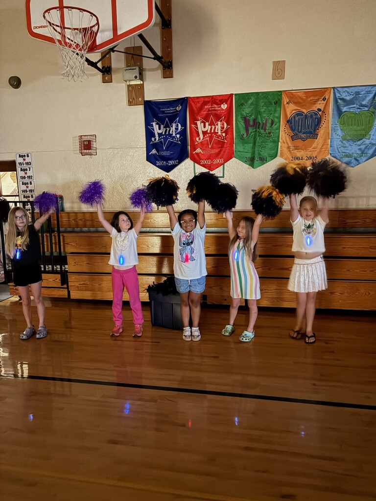 Five students with pompoms over their heads. 