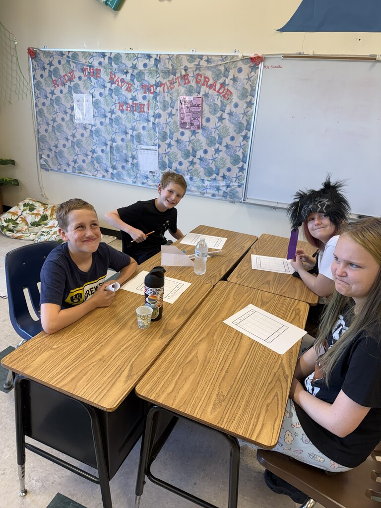 Four students at desks working. 
