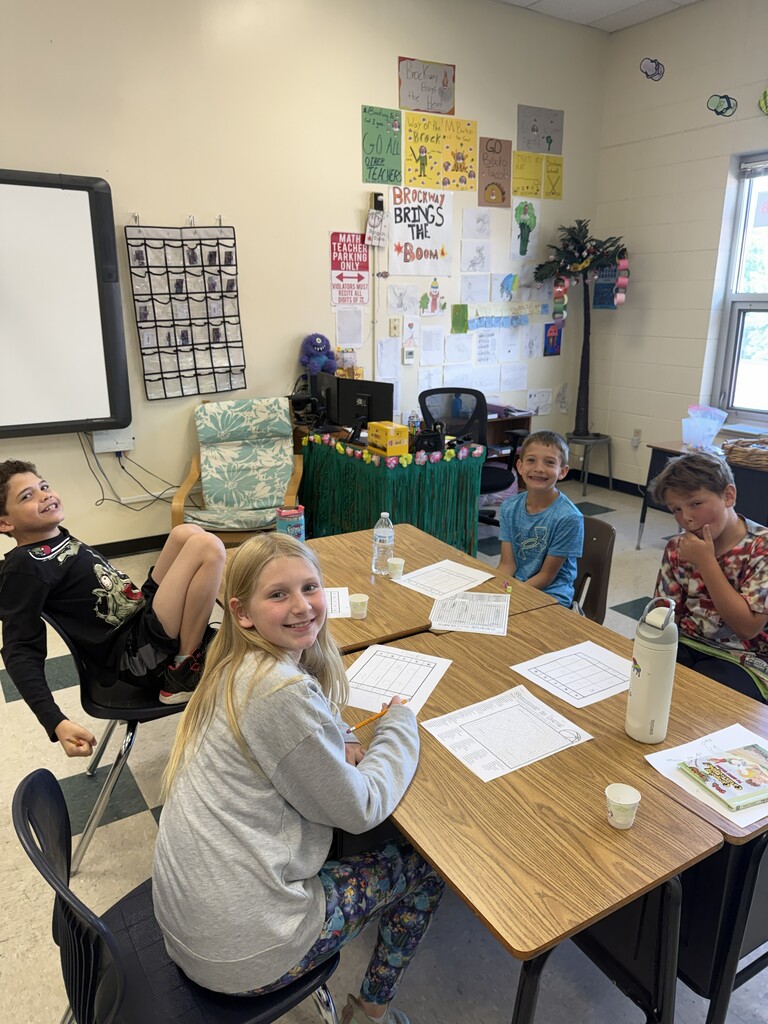 Four students at desks working. 