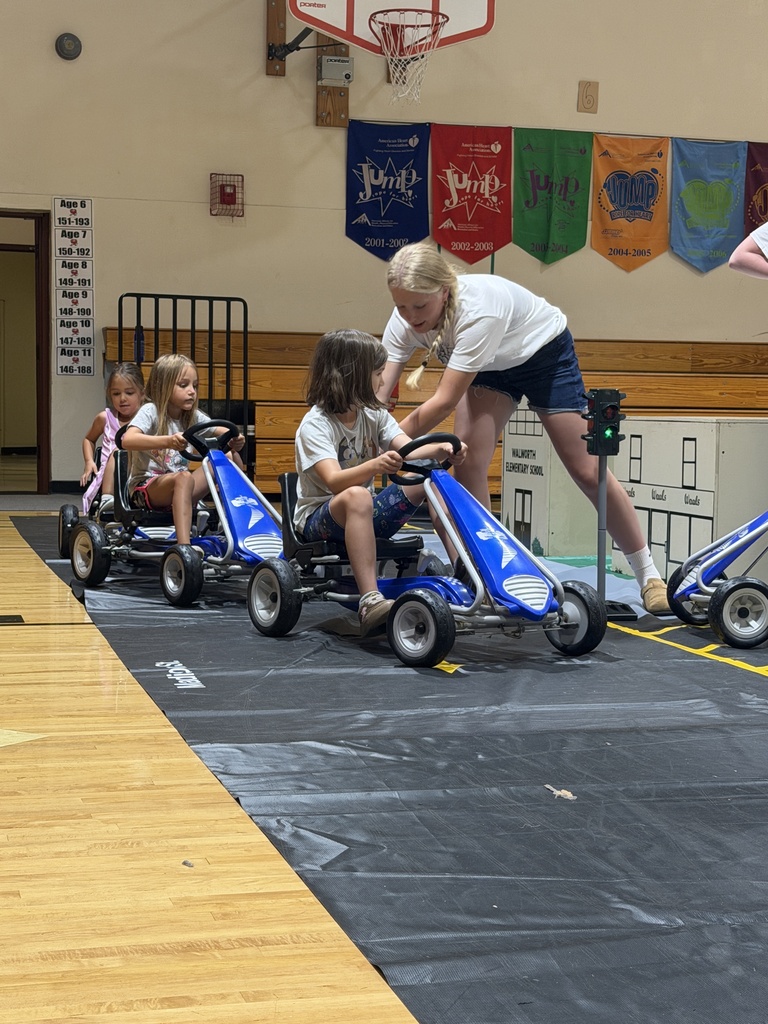 Students riding pedal cars and learning safety rules.