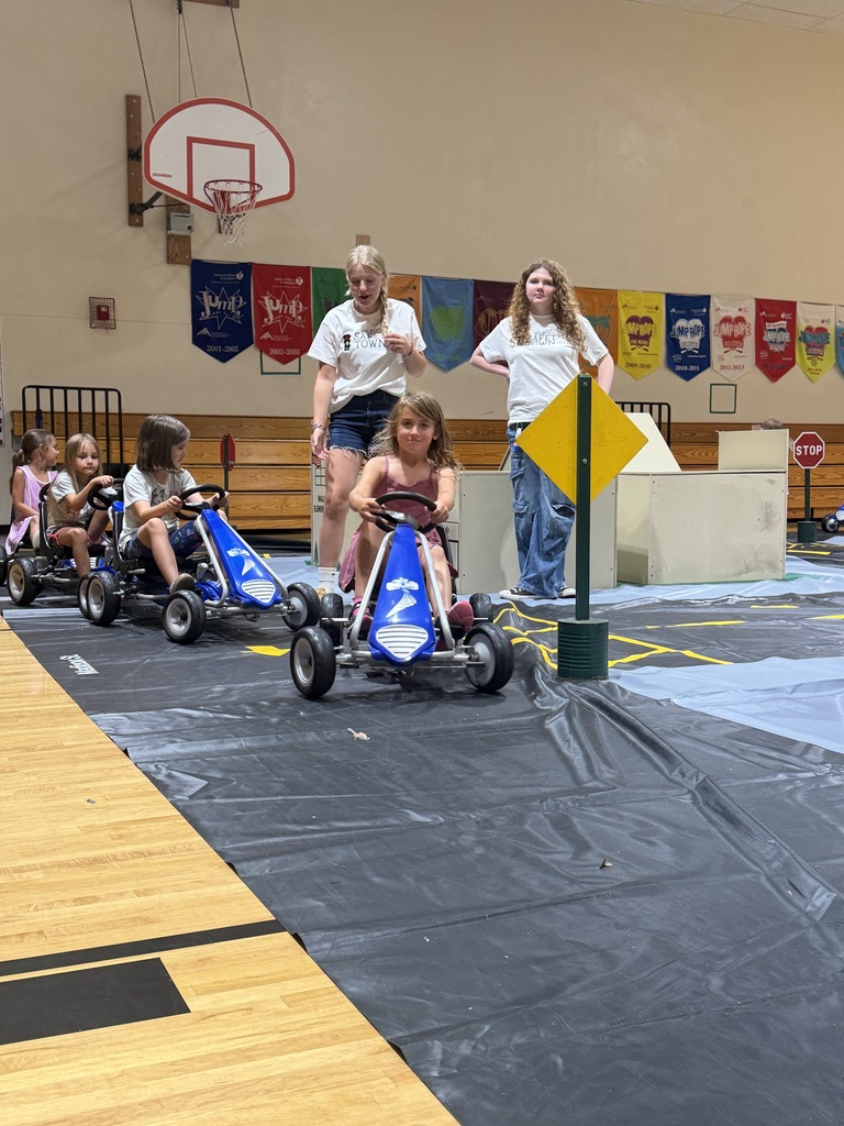 Students riding pedal cars and learning safety rules.