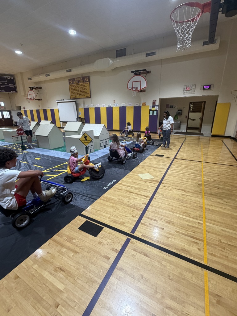 Students practice safety while using pedal cars at Safety Town.