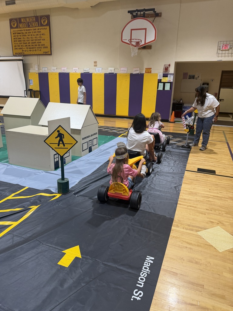 Students using pedal cars to practice at Safety Town. 