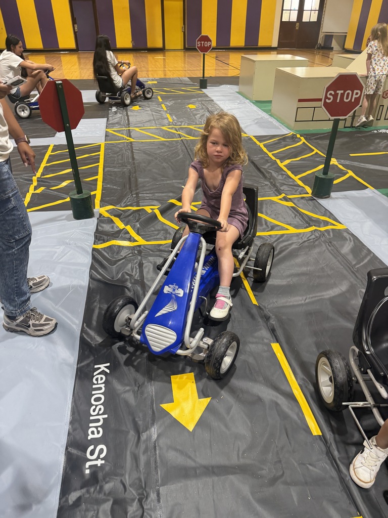 Students practice safety while using pedal cars at Safety Town.