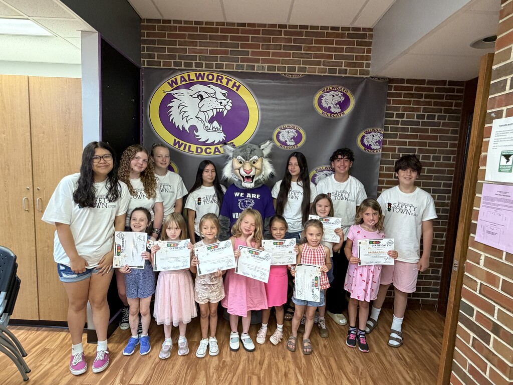 Wesley the Wildcat and middle school ounselors with students and their Safety Town certificates. 