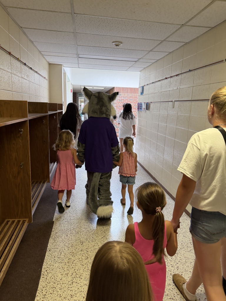 Wesley walking with students in the hallway. 