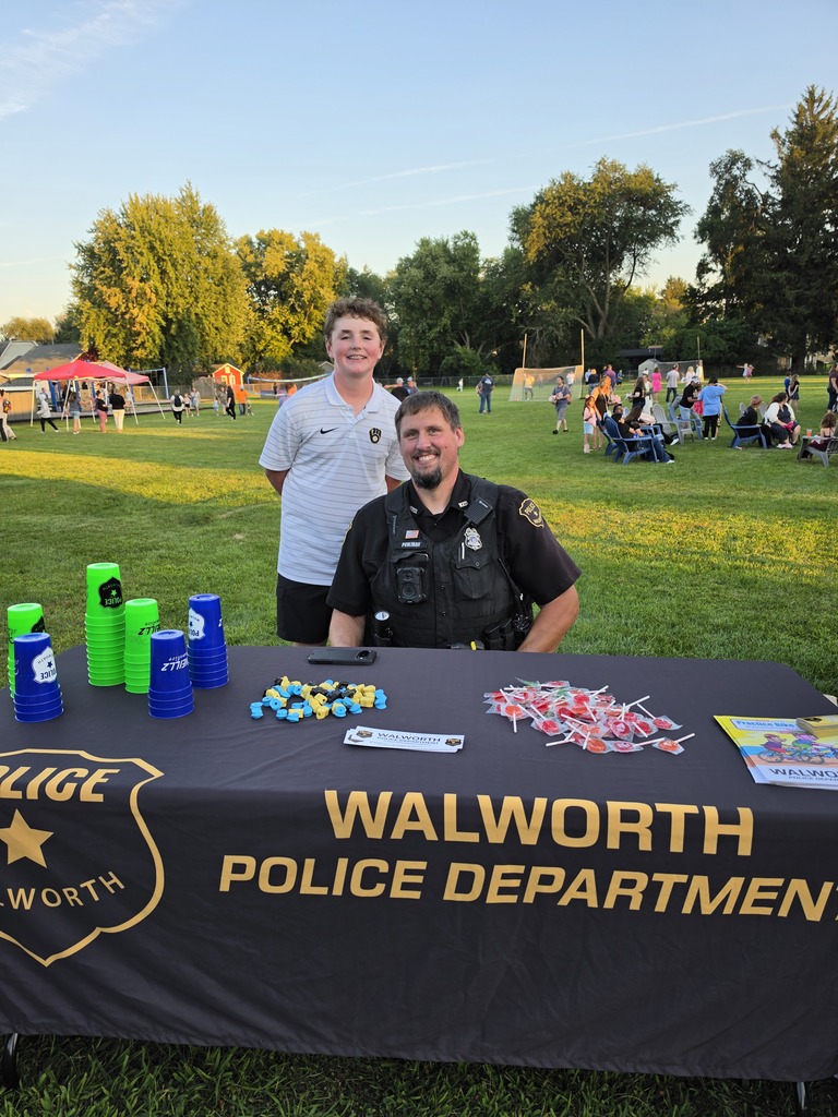 One adult and one youth behind a Walworth Police Department table