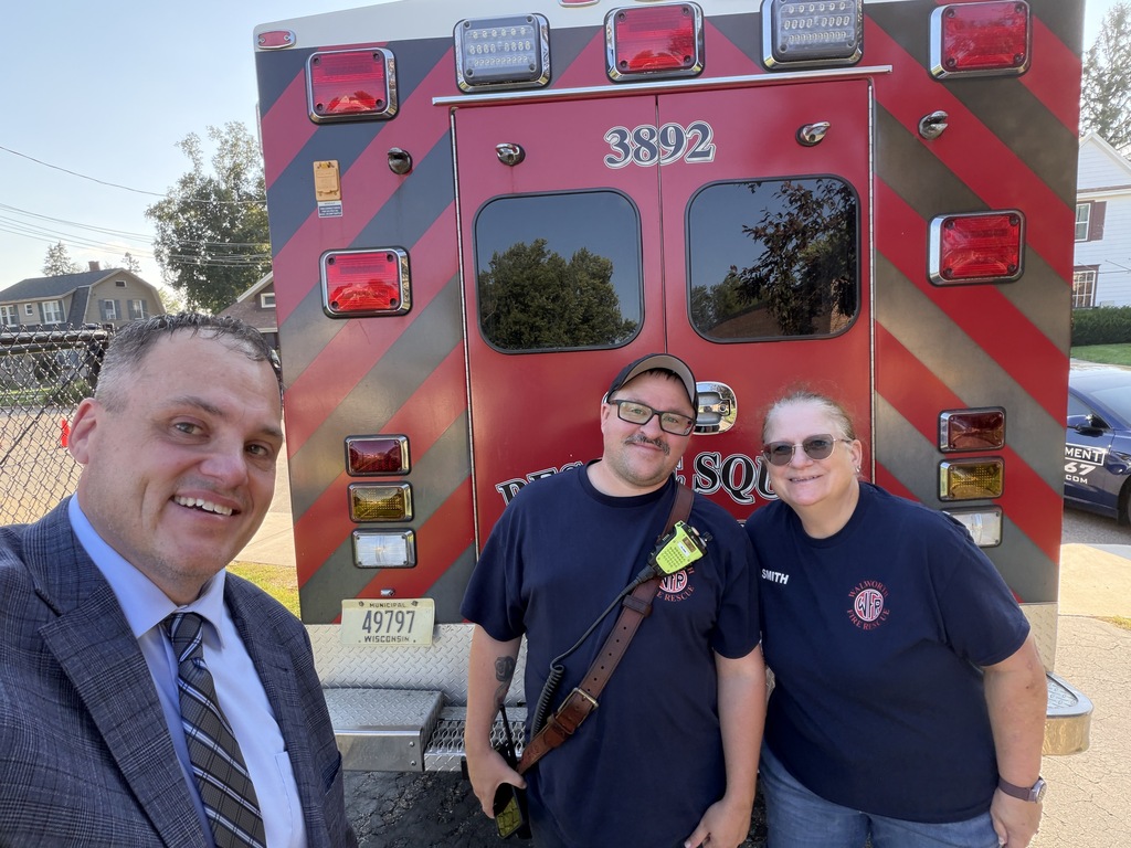 Three adults by a rescue squad