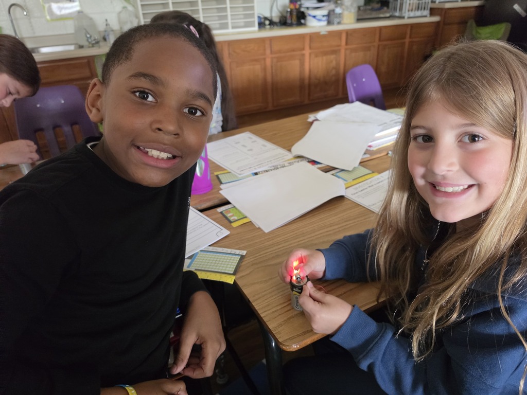 Students lighting a lightbulb with a battery.