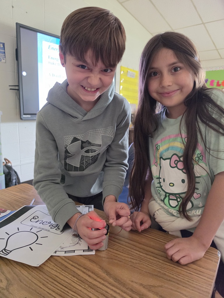 Students lighting a lightbulb with a battery.