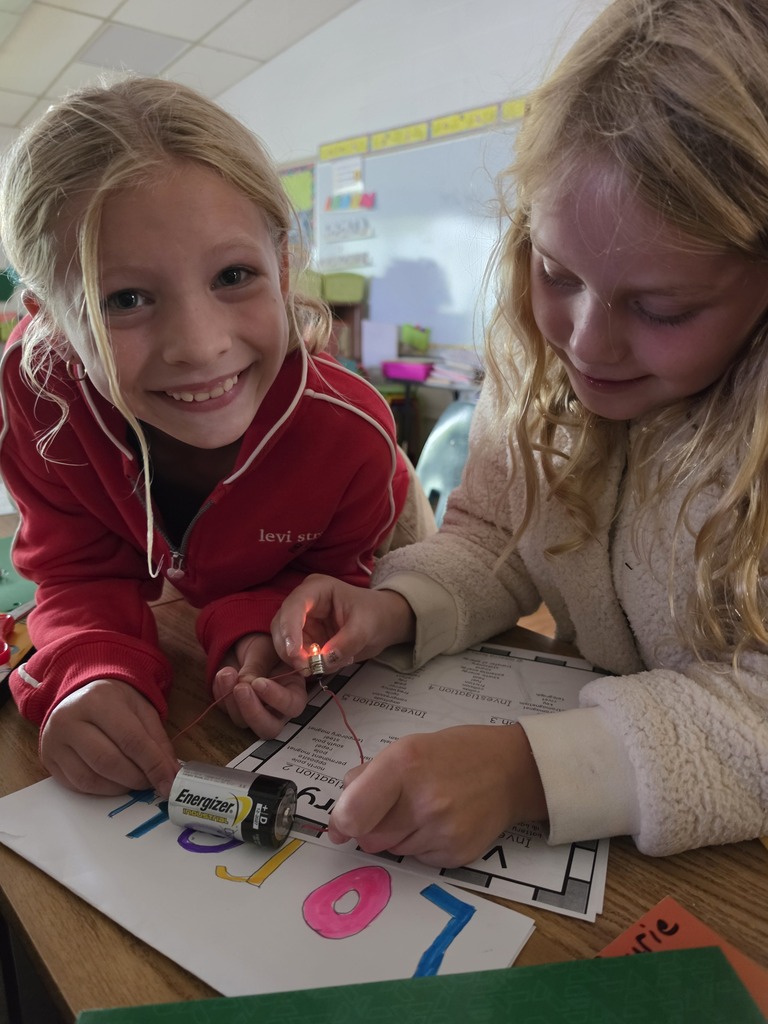 Students lighting a lightbulb with a battery.