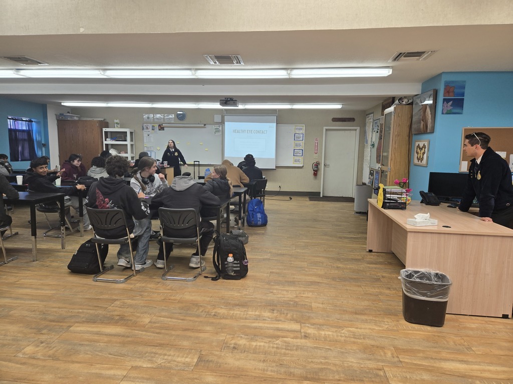 A State FFA Officer leading a communication workshop with Warner FFA members seated in a classroom.
