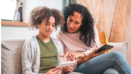 Parent and child discussing content on smart phone.