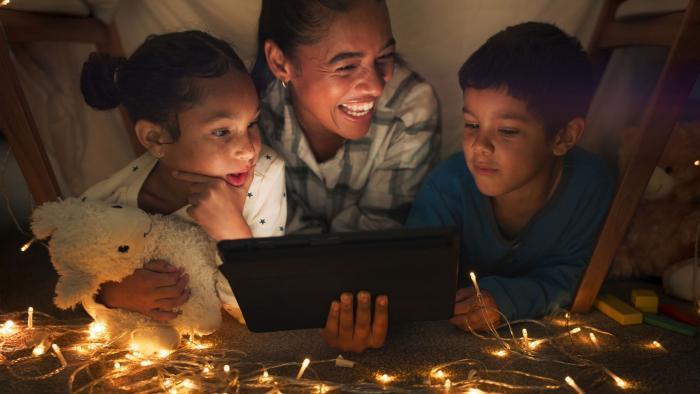 Holiday lights, 2 children, adult on device.