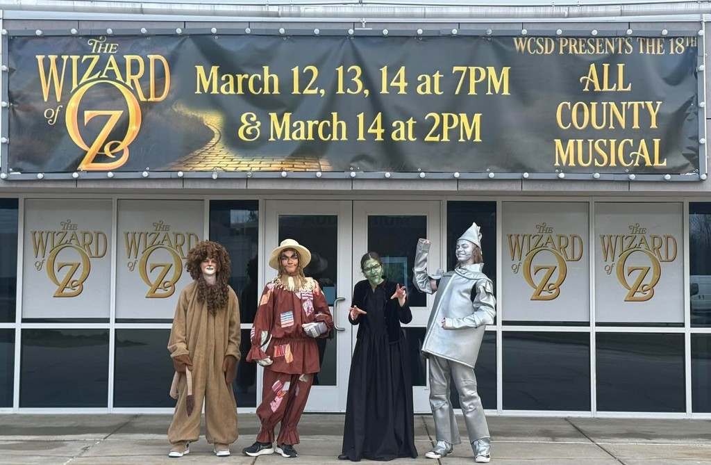 Lion, Scarecrow, Witch, and Tin Man under "The Wizard of Oz" banner