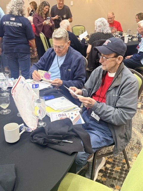 Two Buffalo Niagara Honor Flight veterans reading cards