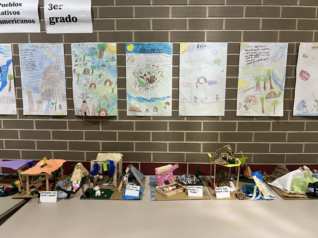 A display of student projects about different types of Native American homes, with drawings and models.