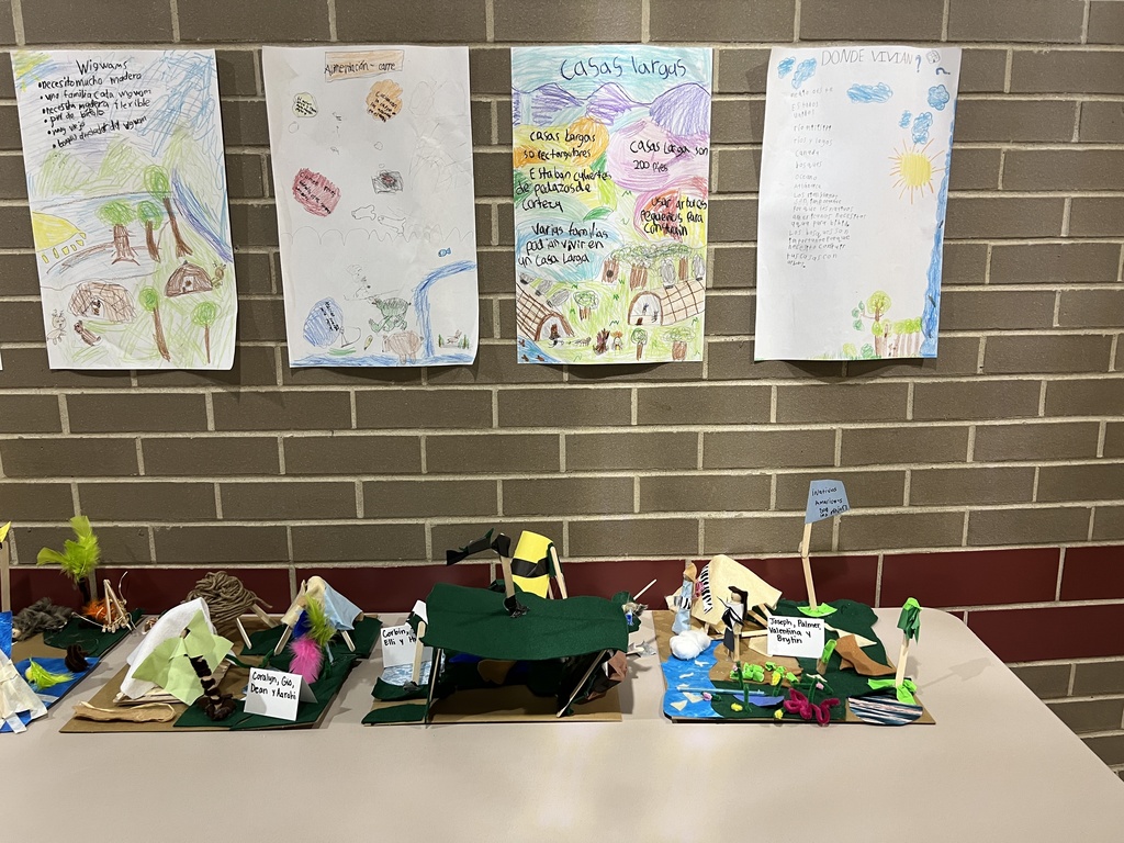 A display of student projects about different types of Native American homes, with drawings and models.