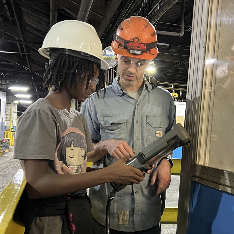 Students tour and operate a robot at Dalton Foundry. 