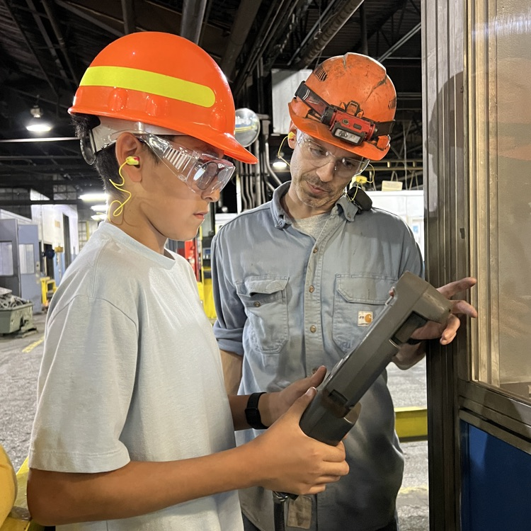 Students tour and operate a robot at Dalton Foundry. 