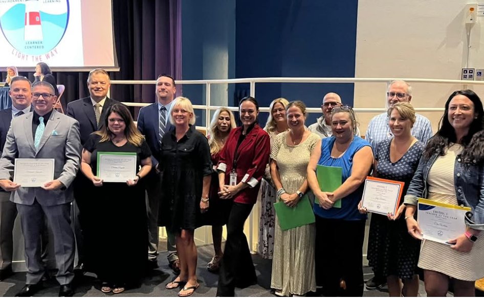 Group of nominees for District Teacher of the Year posing with Warwick School Committee members and Superintendent McCaffrey