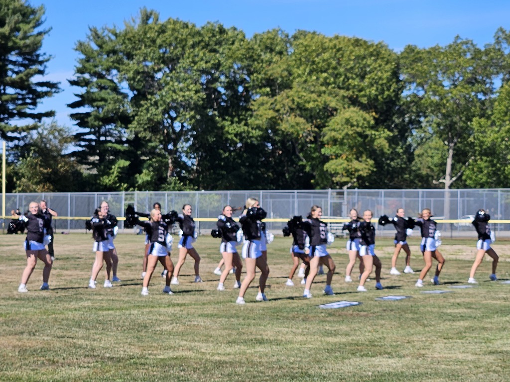 Cheerleaders in the field in front of the tennis courts