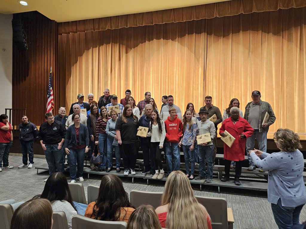 Group of Veterans and their families on the risers in the auditorium