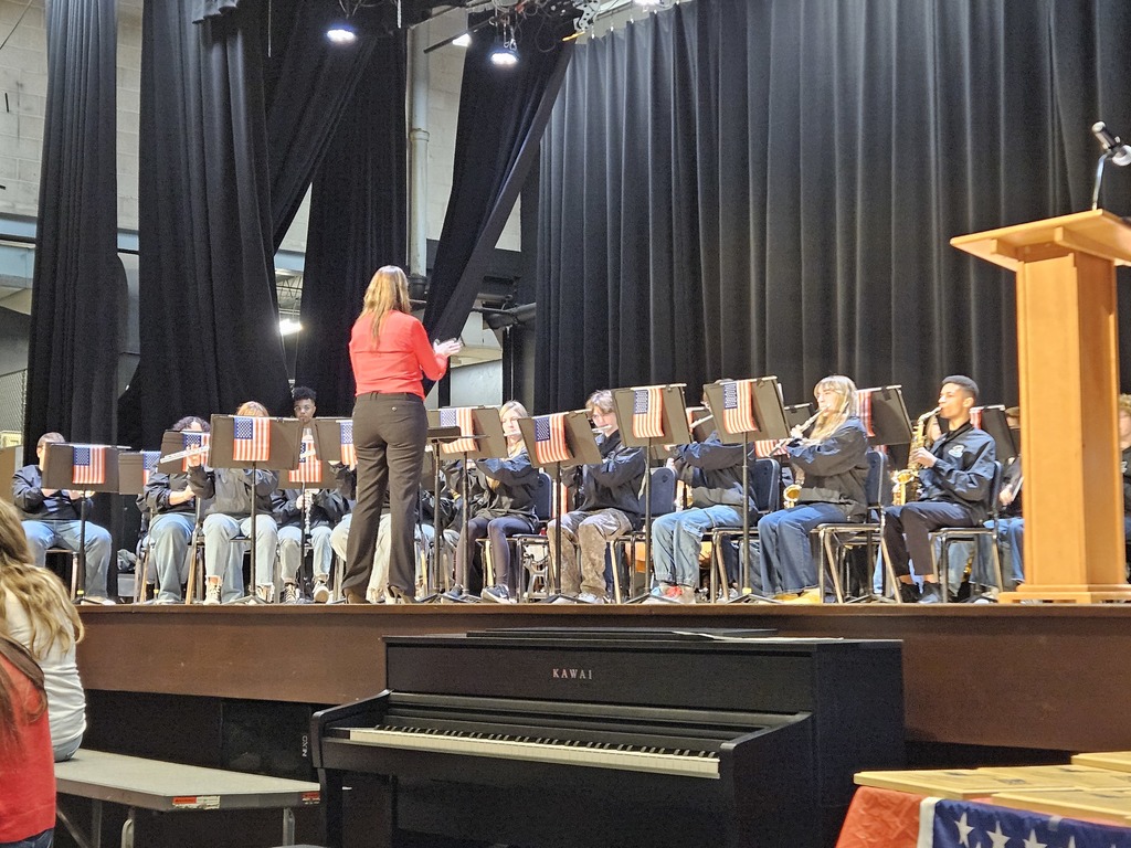 Pilgrim band performing on the stage with American flags hanging off the music stands
