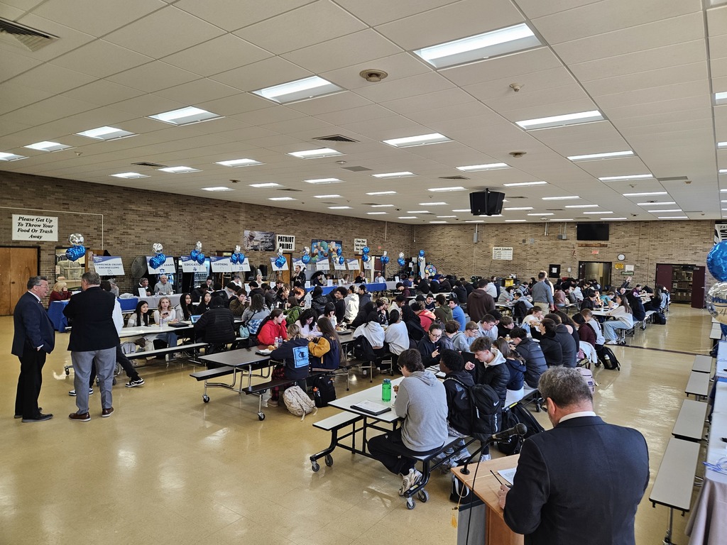 Students sitting in the cafeteria preparing for the financial literacy fair
