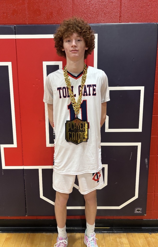 Toll Gate basketball player, Jake Andersen, in uniform wearing a "Player of the Game" award.
