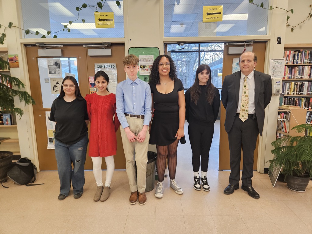 Students that won the science fair with their teacher in the library