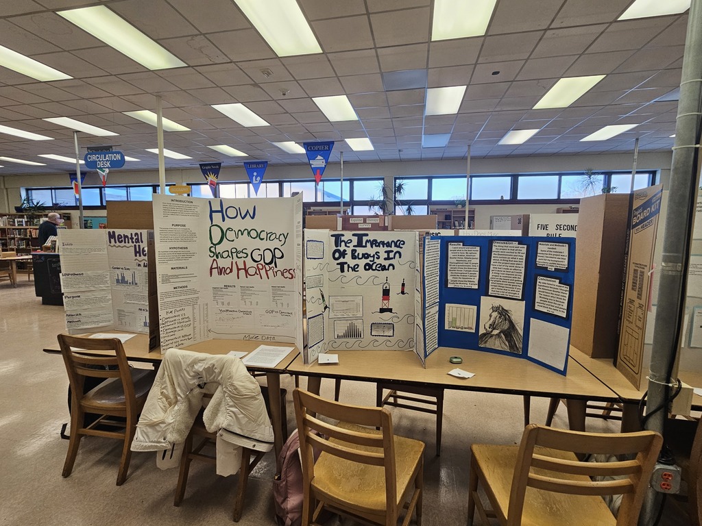 Trifold boards on tables with information about different science fair projects