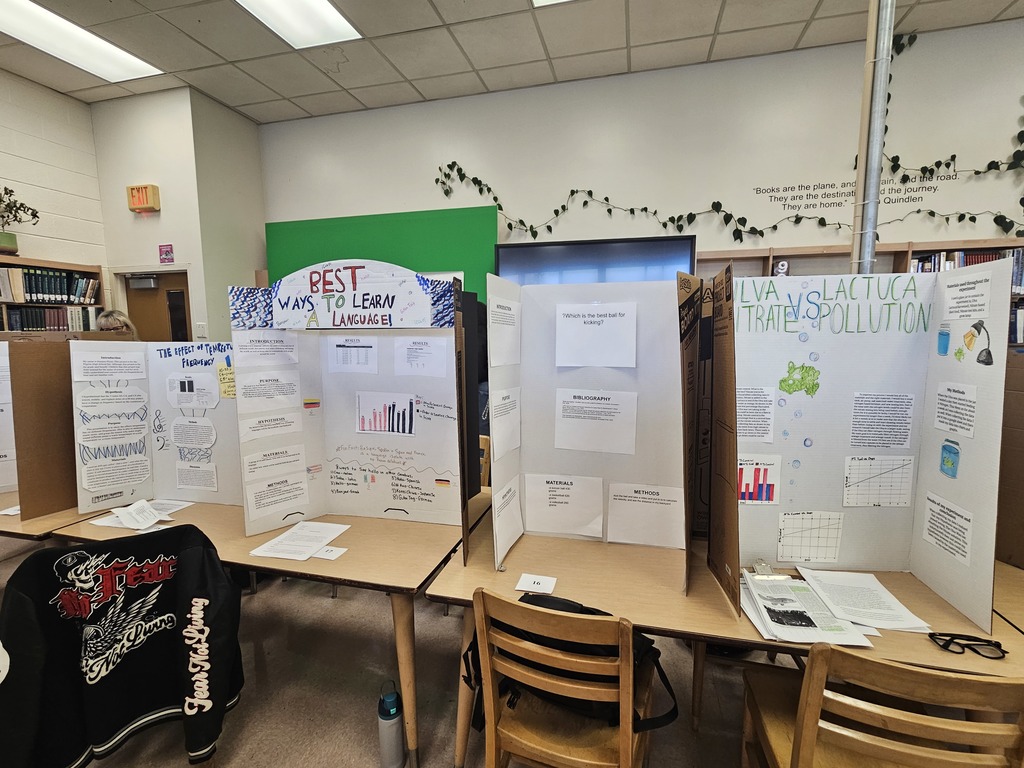 Trifold boards on tables with information about different science fair projects