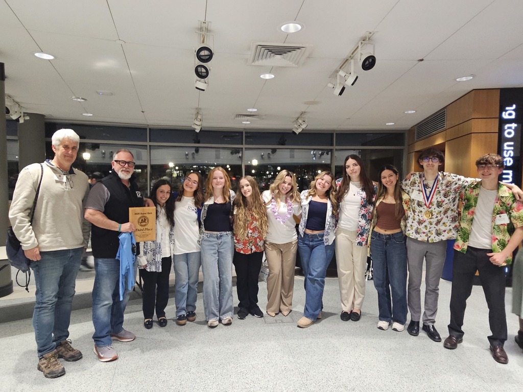 Students and teachers holding plaque after a competition