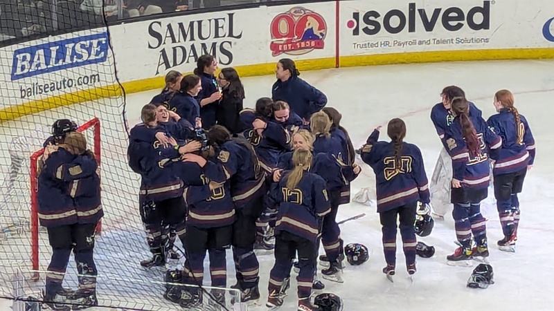 Girls Hockey team celebrating on ice