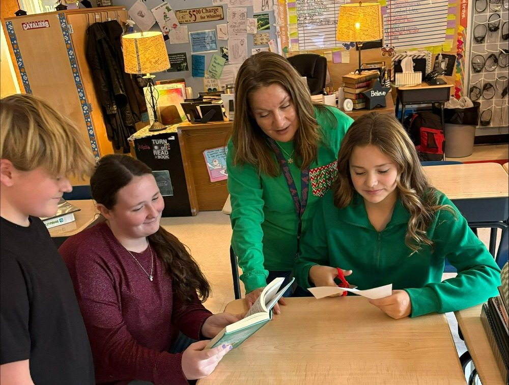 A teacher works with three students in a classroom.