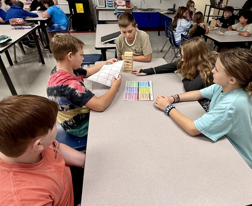 Students play Jenga at a table.