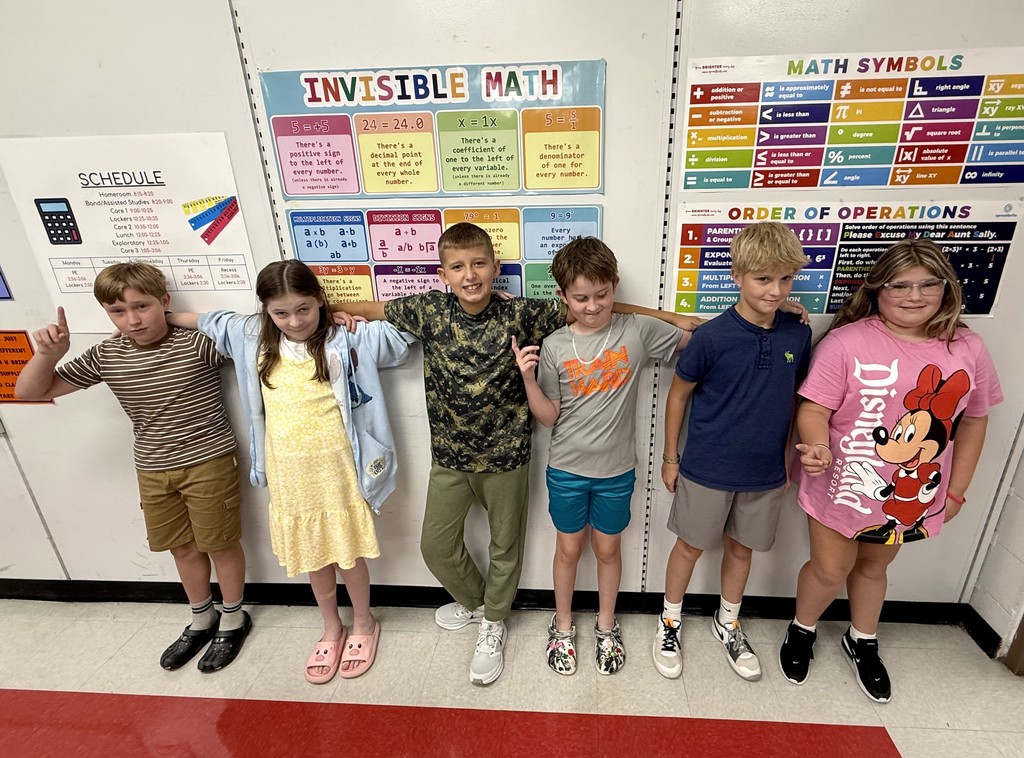 Students pose together in front of a wall.