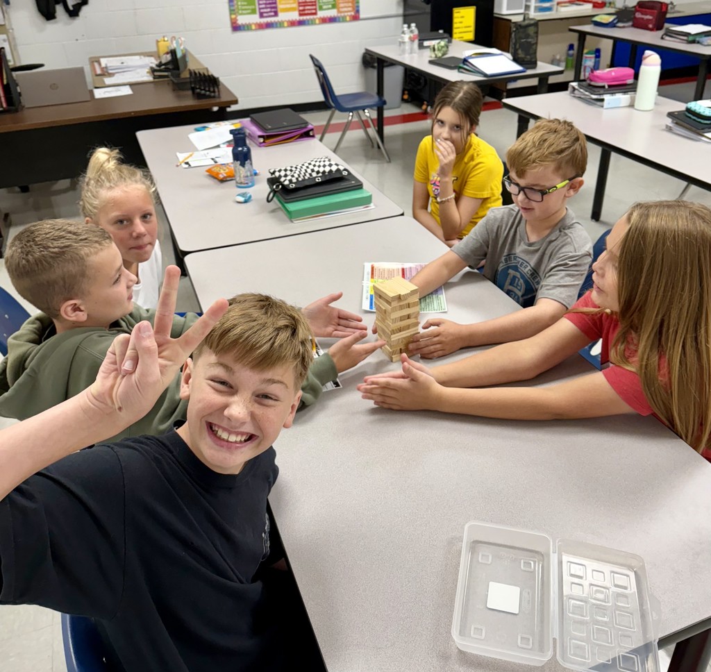 Students play Jenga at a table.
