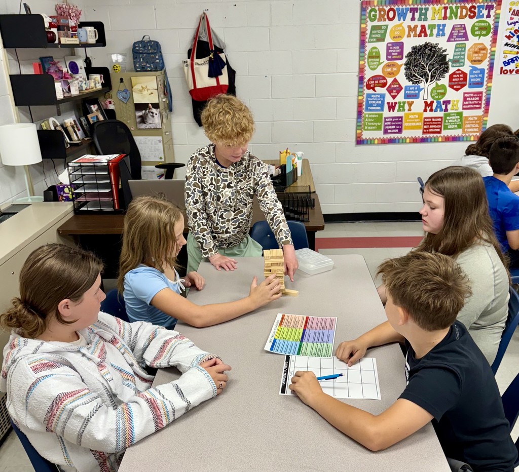 Students play Jenga at a table.