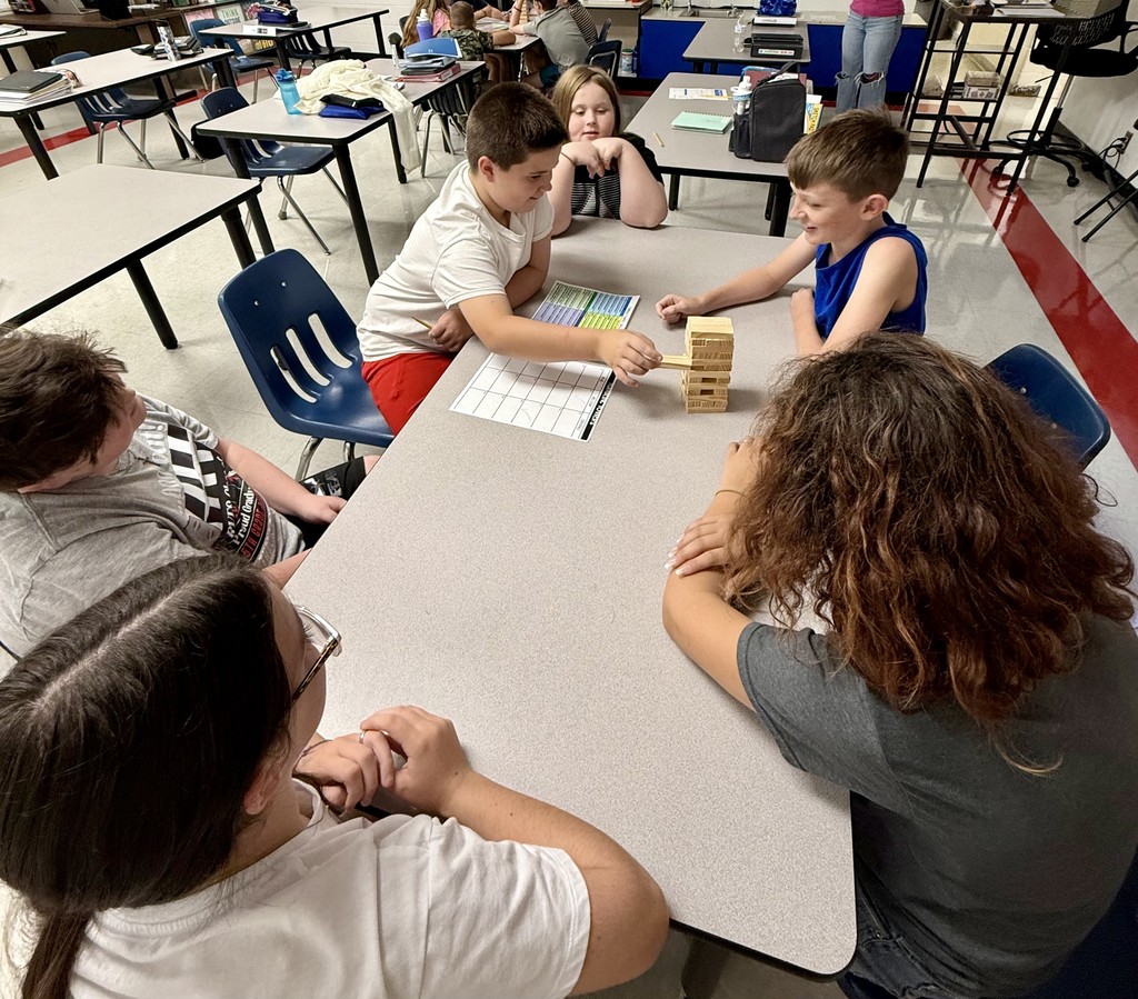 Students play Jenga at a table.