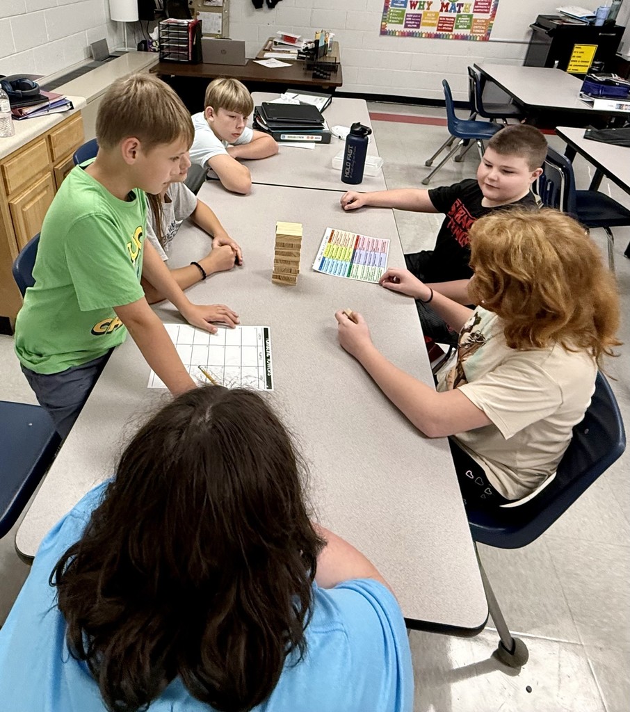 Students play Jenga at a table.